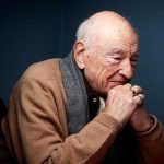 Edgar Morin reflexionando con las manos entrelazadas, retrato del filósofo y sociólogo francés impulsor del pensamiento complejo.